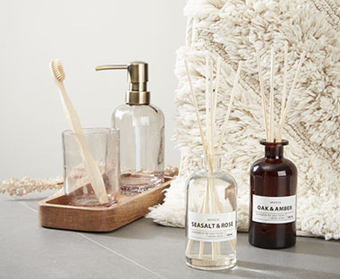 Soap dispenser and toothbrush holder made from recycled glass and natural bath mat made from 100% cotton