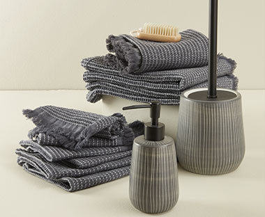 Grey 100% cotton hand towel, wood nail brush and grey soap dispenser and toilet brush made from stoneware