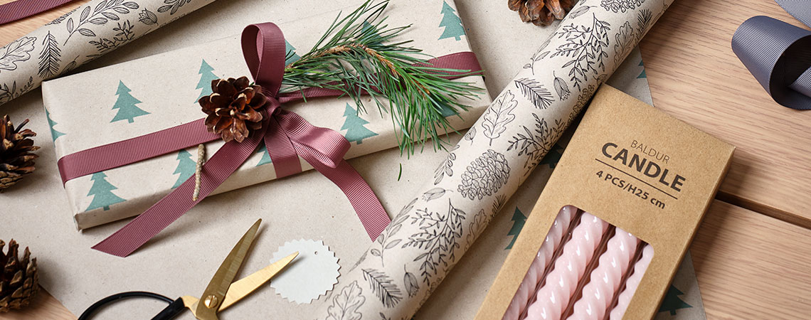 A table with wrapping paper, Christmas décor and presents  