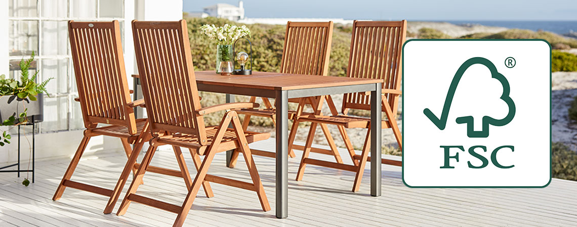 Brown rectangle outdoor table with wooden chairs with FSC label in bright garden