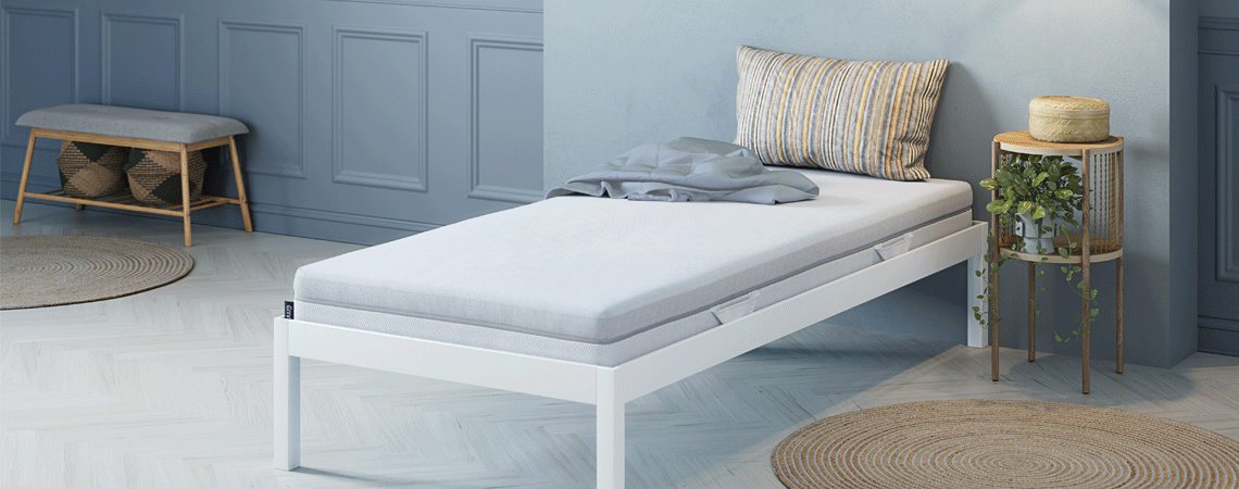 Single bed with white bed frame and mattress and round bed side tables
