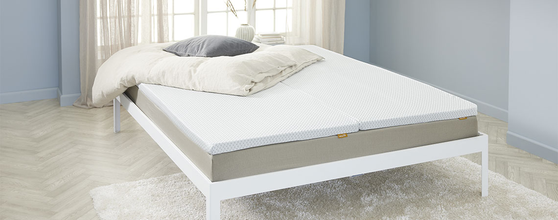 White bed frame with mattress and mattress topper in light blue bedroom