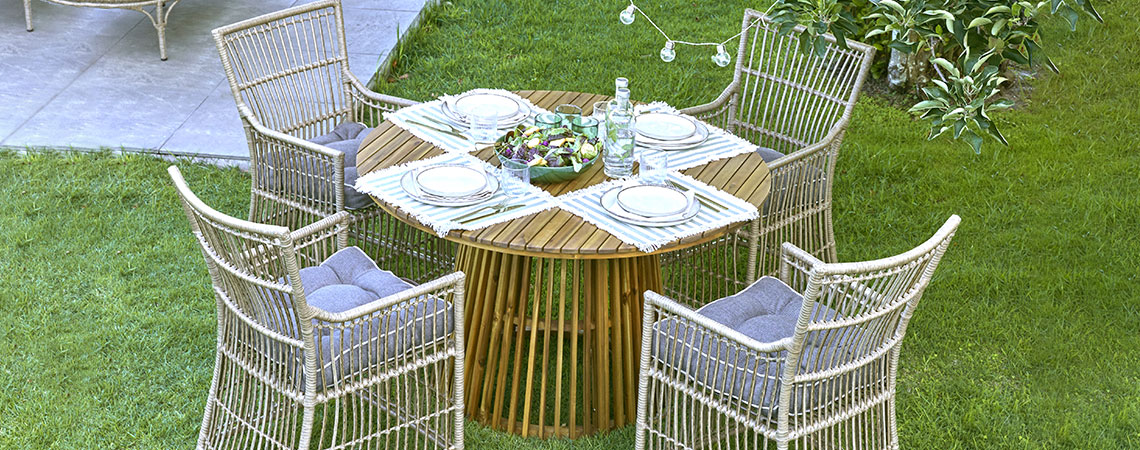 Round garden table and four garden chairs on a lawn 