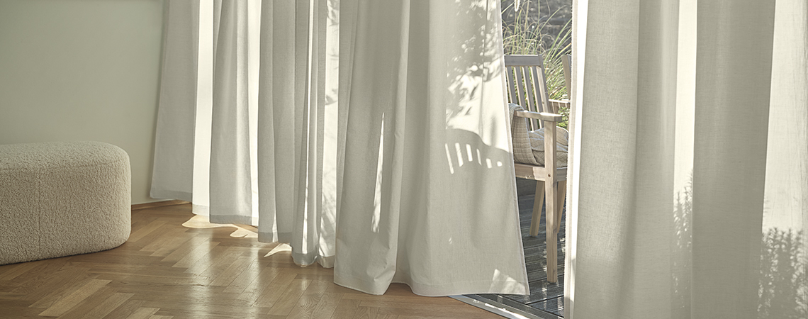 Curtains hanging on curtain rods in front of windows in dining room