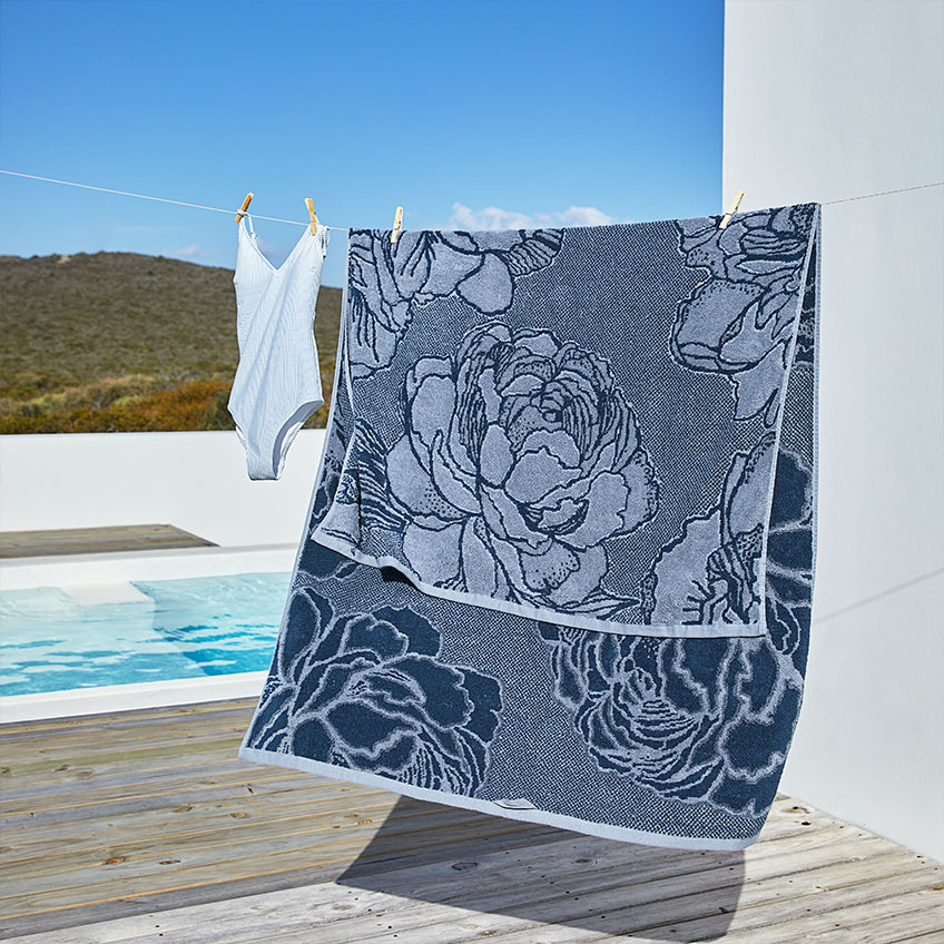 BACKA beach towel in blue with flower pattern Large blue beach towel with flower pattern on laundry line