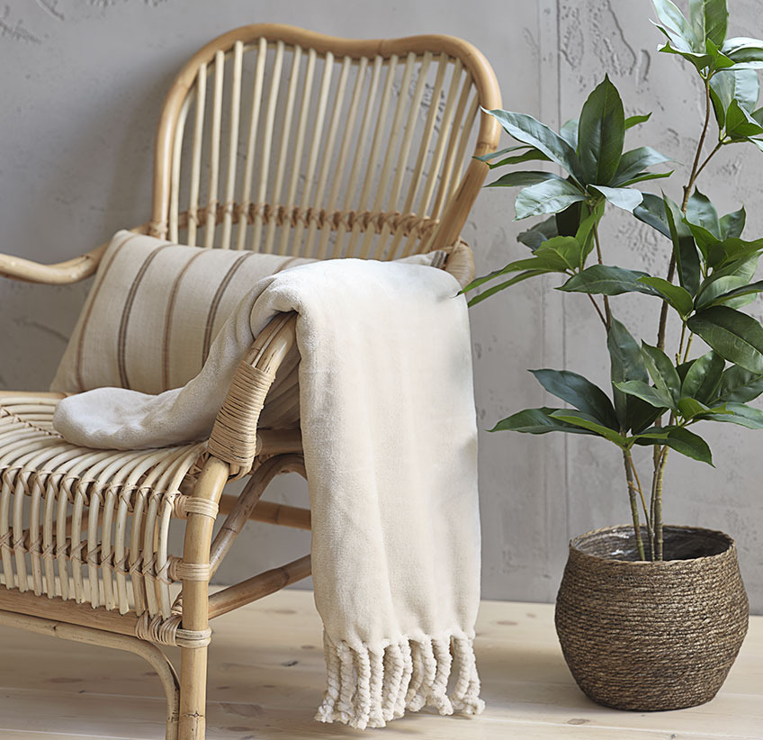 BONDEROSE throw and TRISTAN artificial plant in SIVERT plant pot Beige throw on rattan lounge chair and artificial plant in plant pot