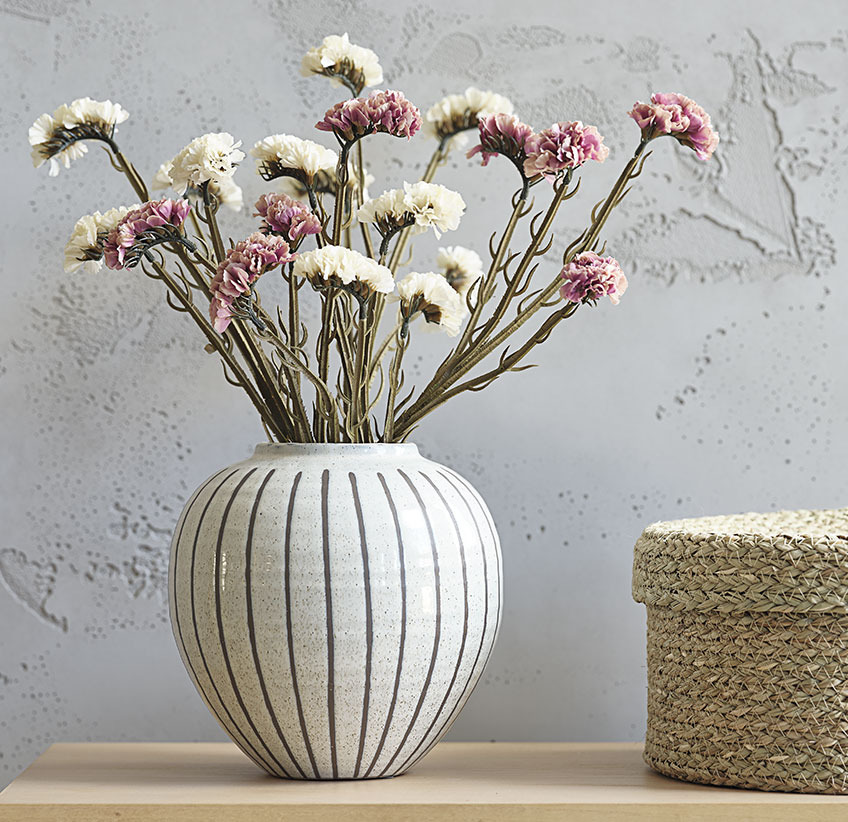 Rose and white artificial dried flowers in white vase with grey stripe pattern