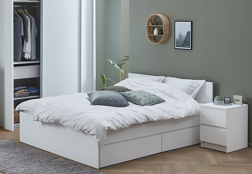 White bed with drawers and white bedside table with drawers