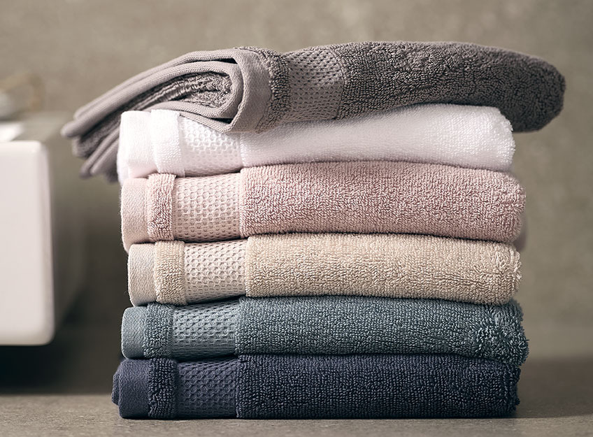 NORA towels are available in several colours Stack of towels in a bathroom