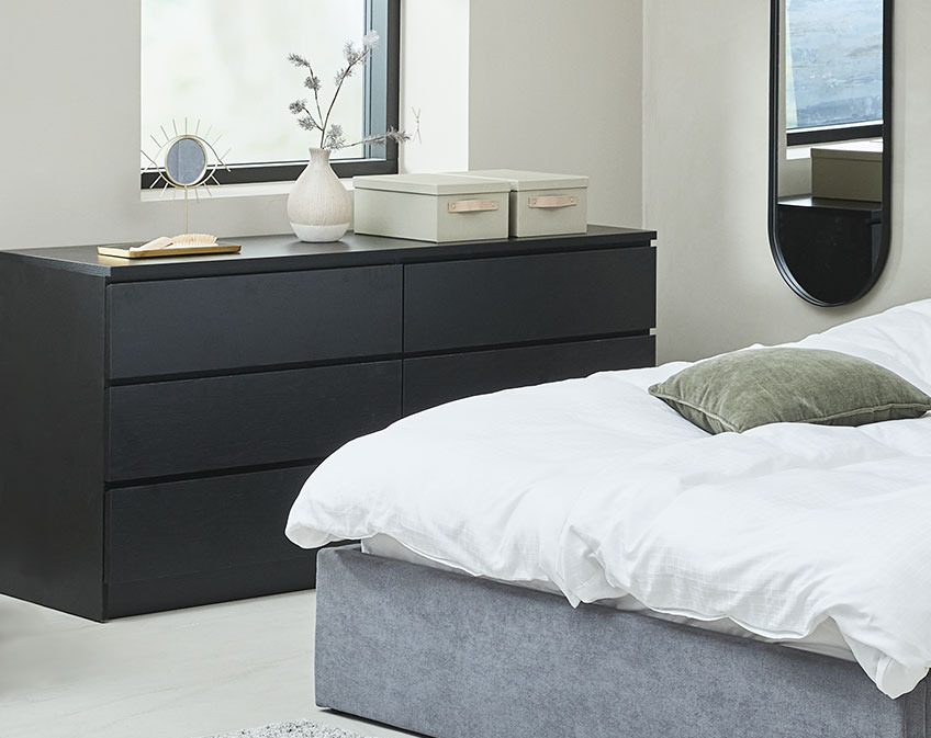 Black chest of drawers in a bedroom