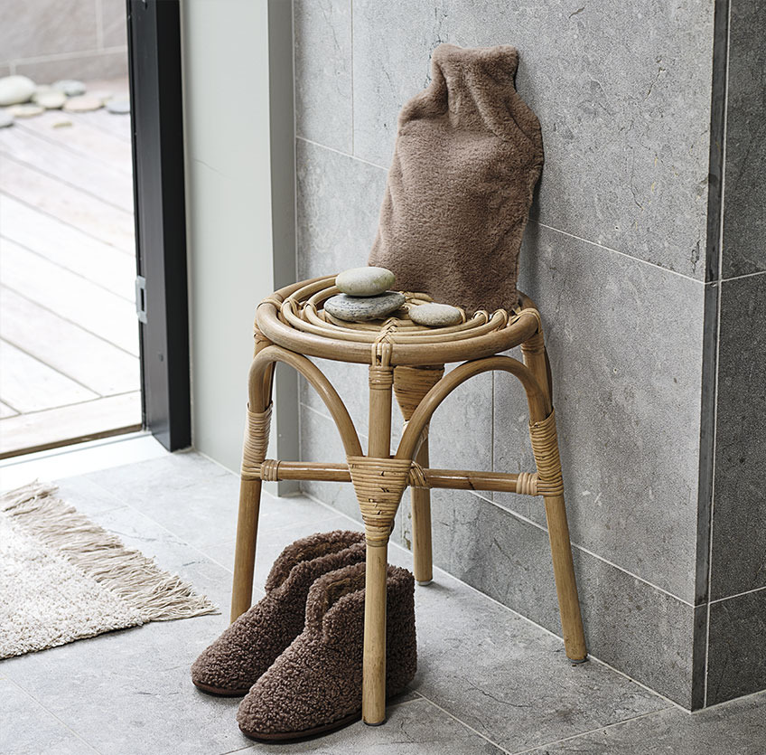 JUNGHOLM stool, SIKFORS slippers and KRAMFORS hot water bottle in brown teddy fabric Slippers under a stool with hot water bottle on top