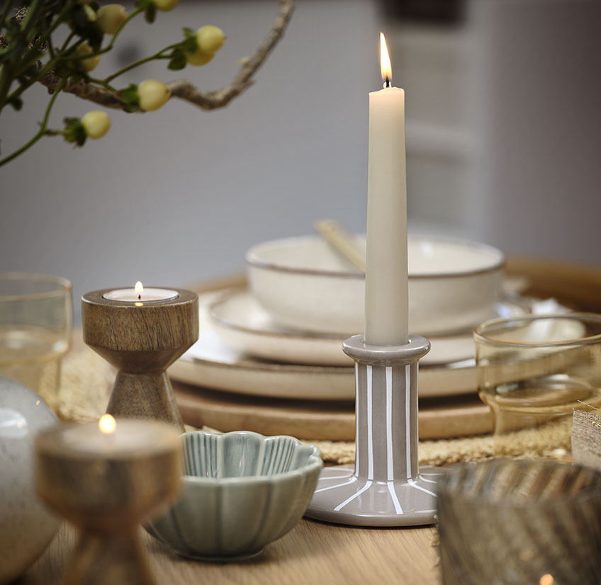 Dinner table setting with tealights and taper candles in candlesticks