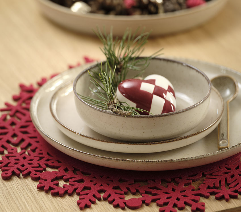 Red placemat with plates, bowl and decoration 