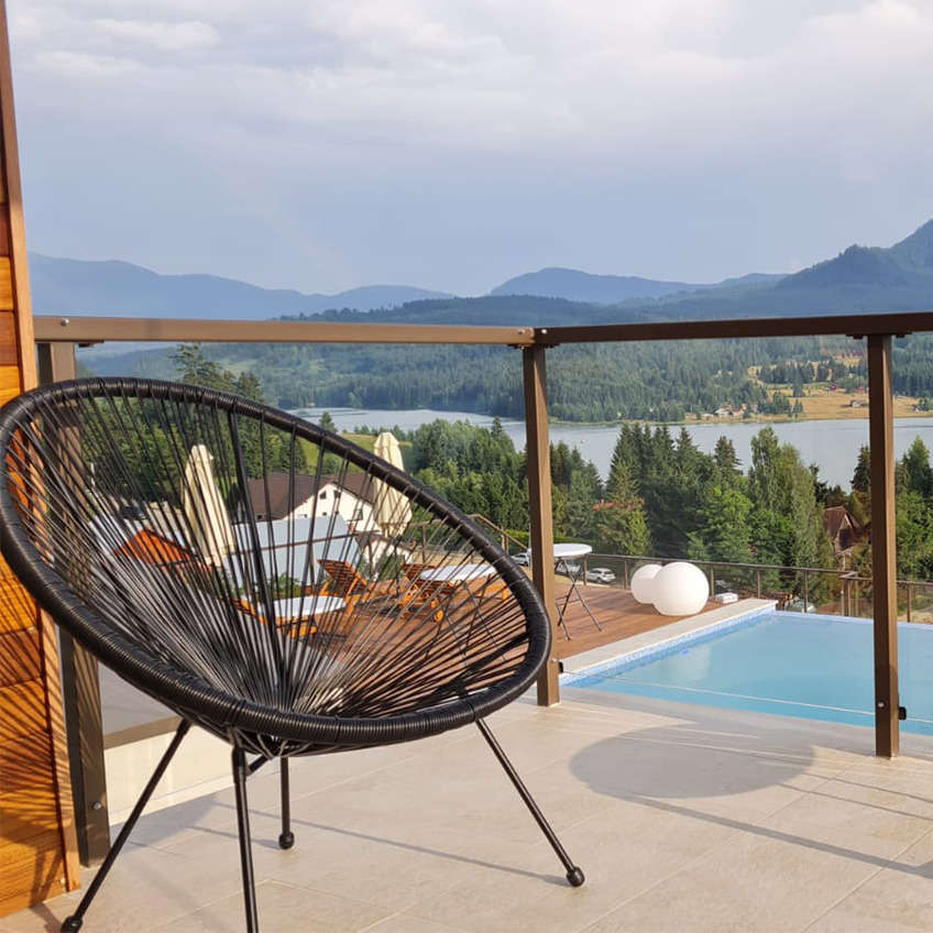 UBBERUP lounge chair Furnished pool area with chair and mountains in background