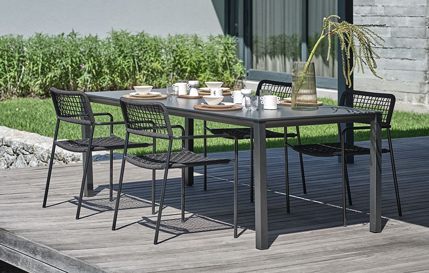 Garden table with table top made from composite wood and garden chairs 