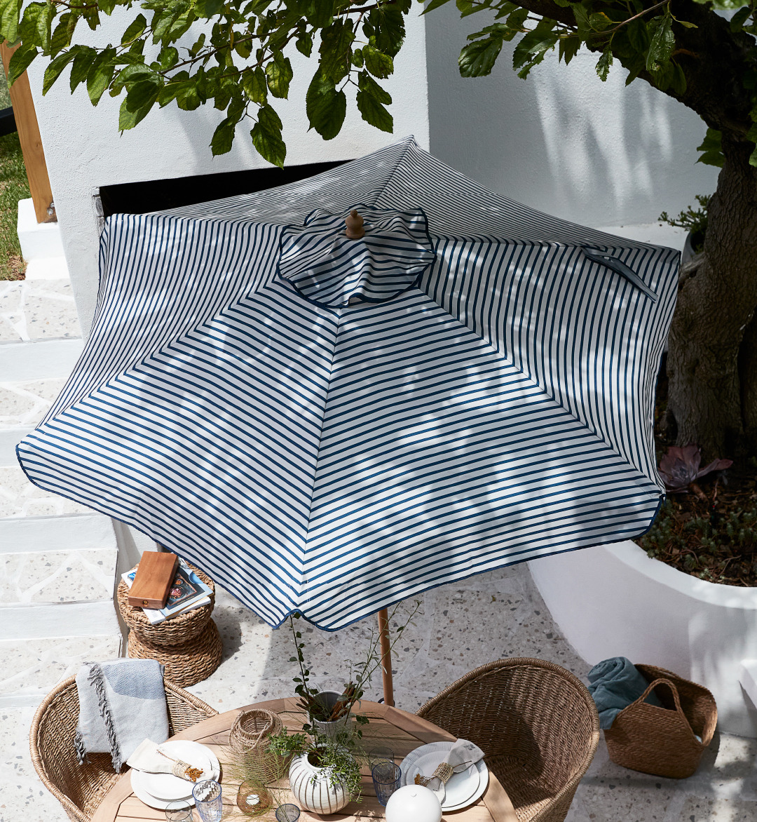 White and blue striped parasol above garden table