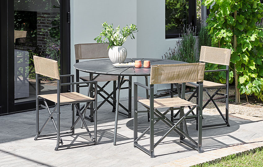 Garden table with fibre cement table top and garden chairs in garden 