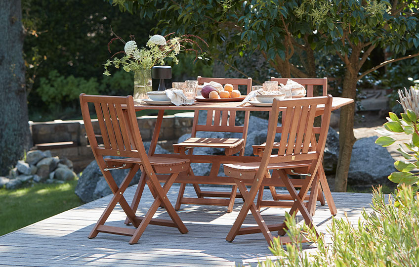Solid eucalyptus garden table and garden chairs on patio 