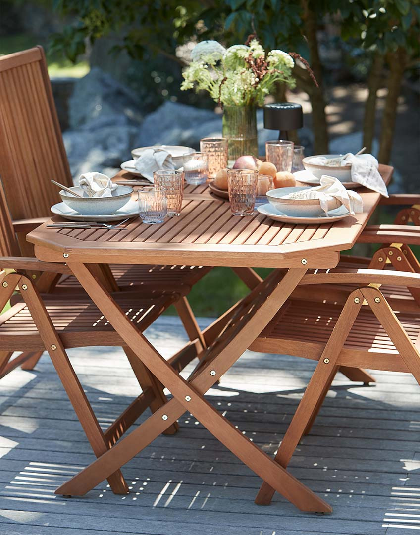 Outdoor table and garden chairs made from solid eucalyptus on patio