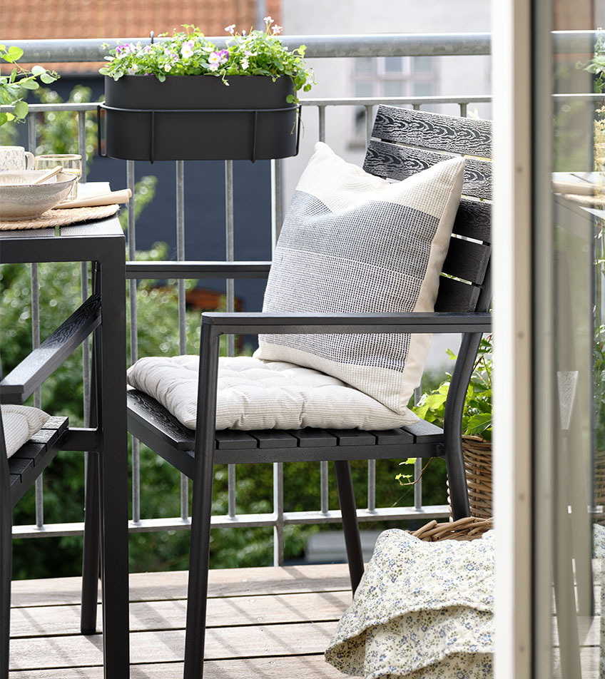 Black stacking garden chair with cushions on balcony