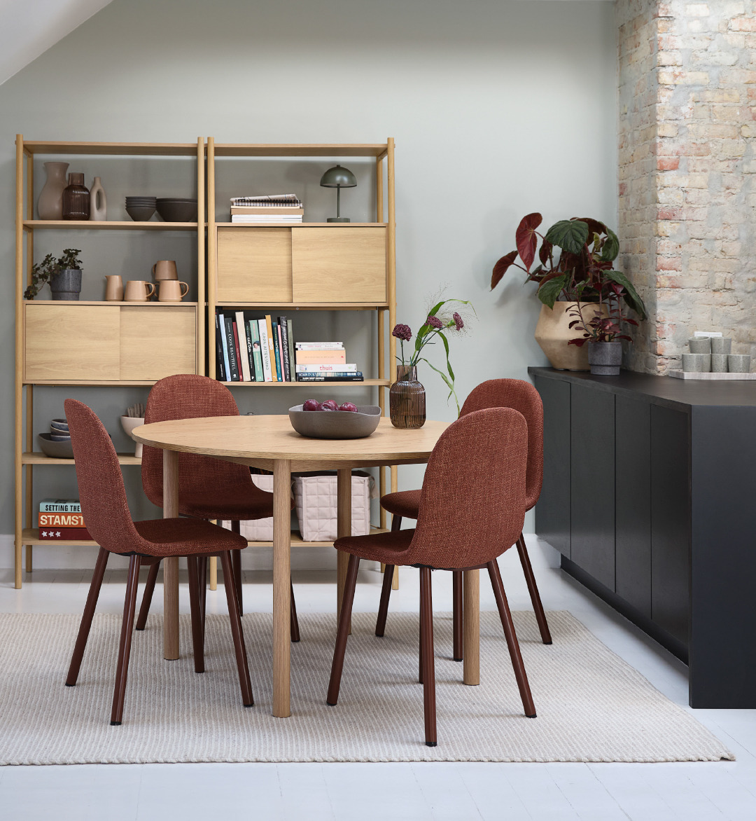 Oak shelving unit and dining table with four terracotta dining chairs