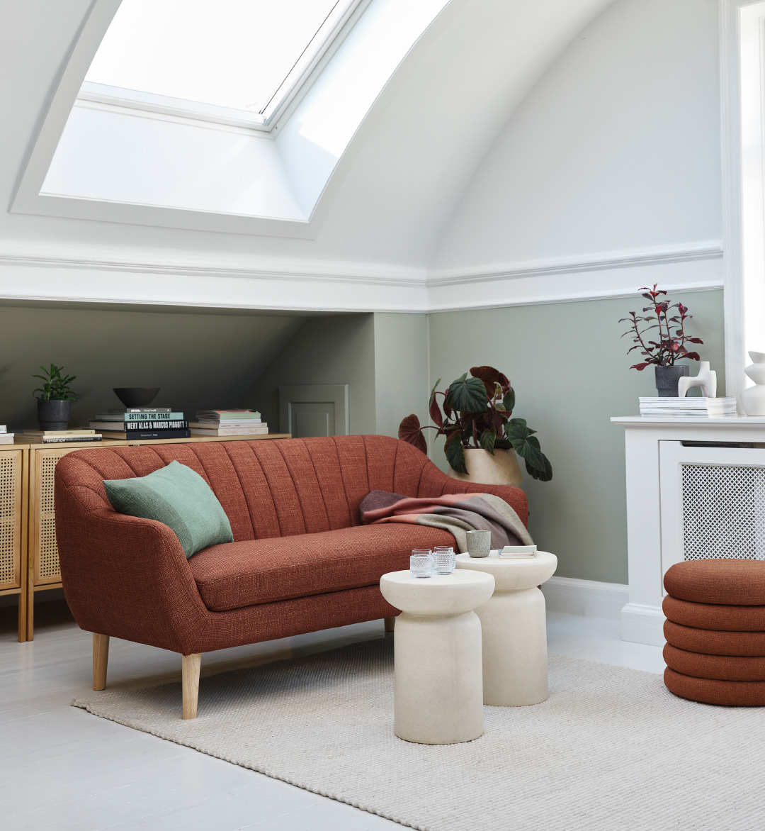 Terracotta sofa and pouffe with a set of end tables in a living room