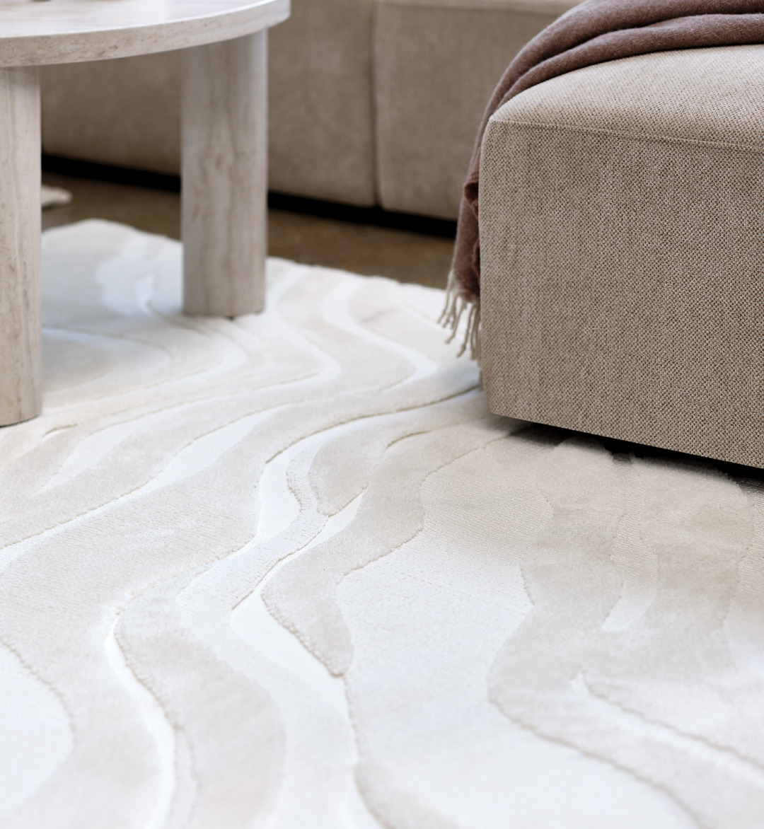 Close up of beige rug and a coffee table and sofa