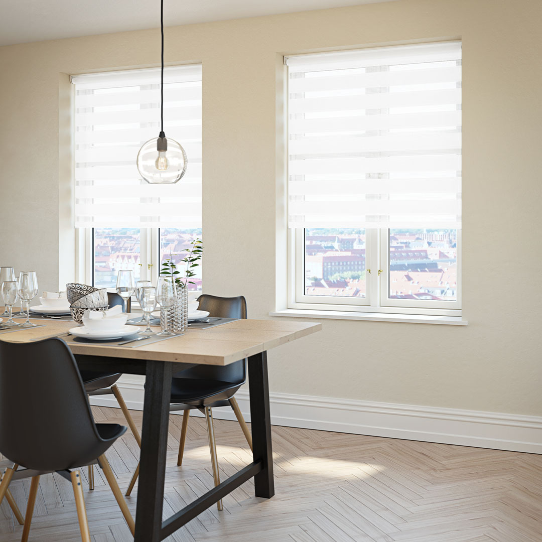 White roller blinds in a dining room next to dining table and chairs