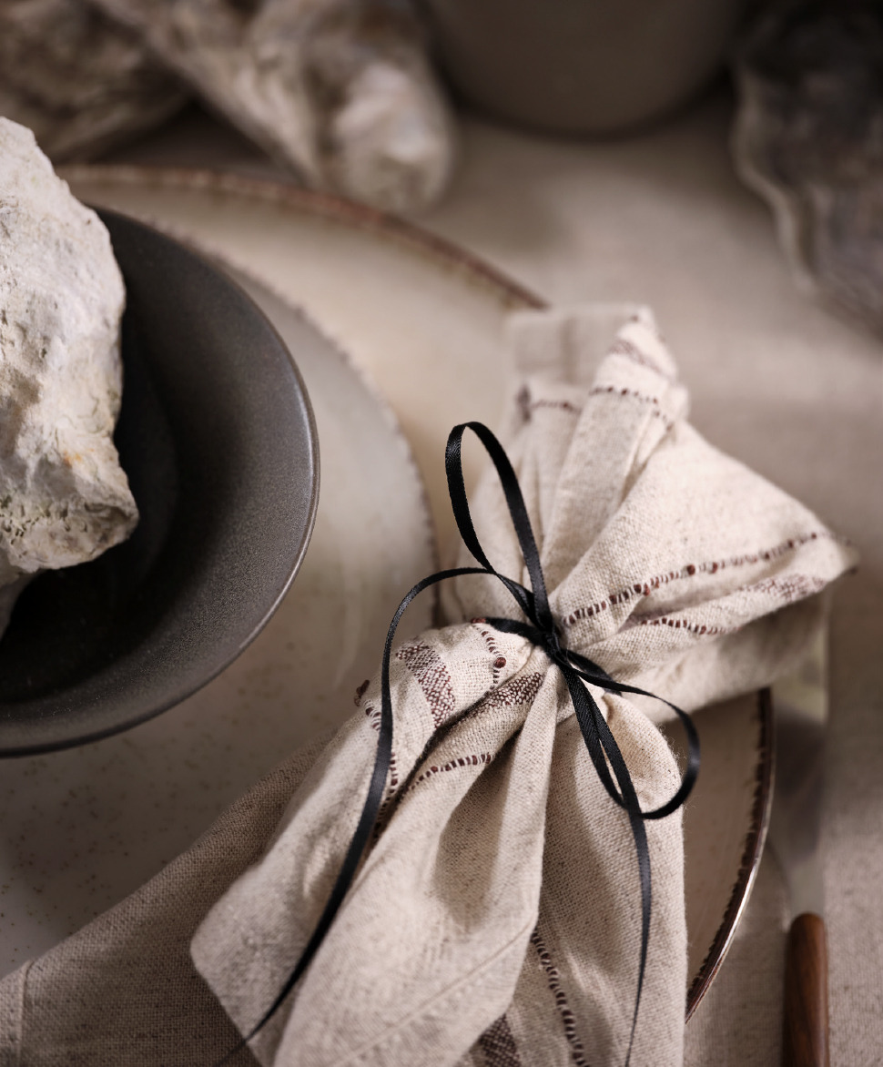 KASTANIE cloth napkin Natural coloured decorative napkin on top of decorative plates