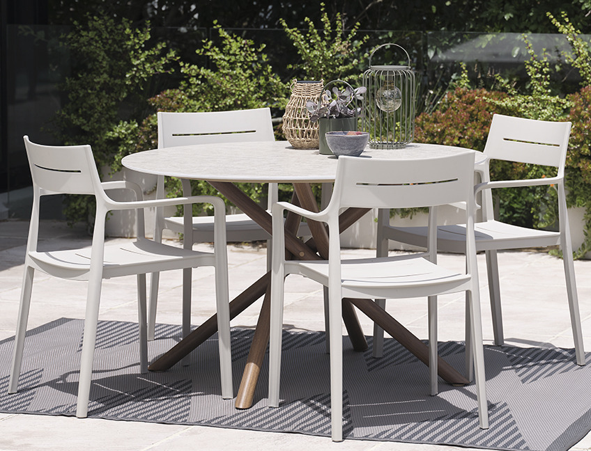 Round garden table and garden chairs on patio in garden