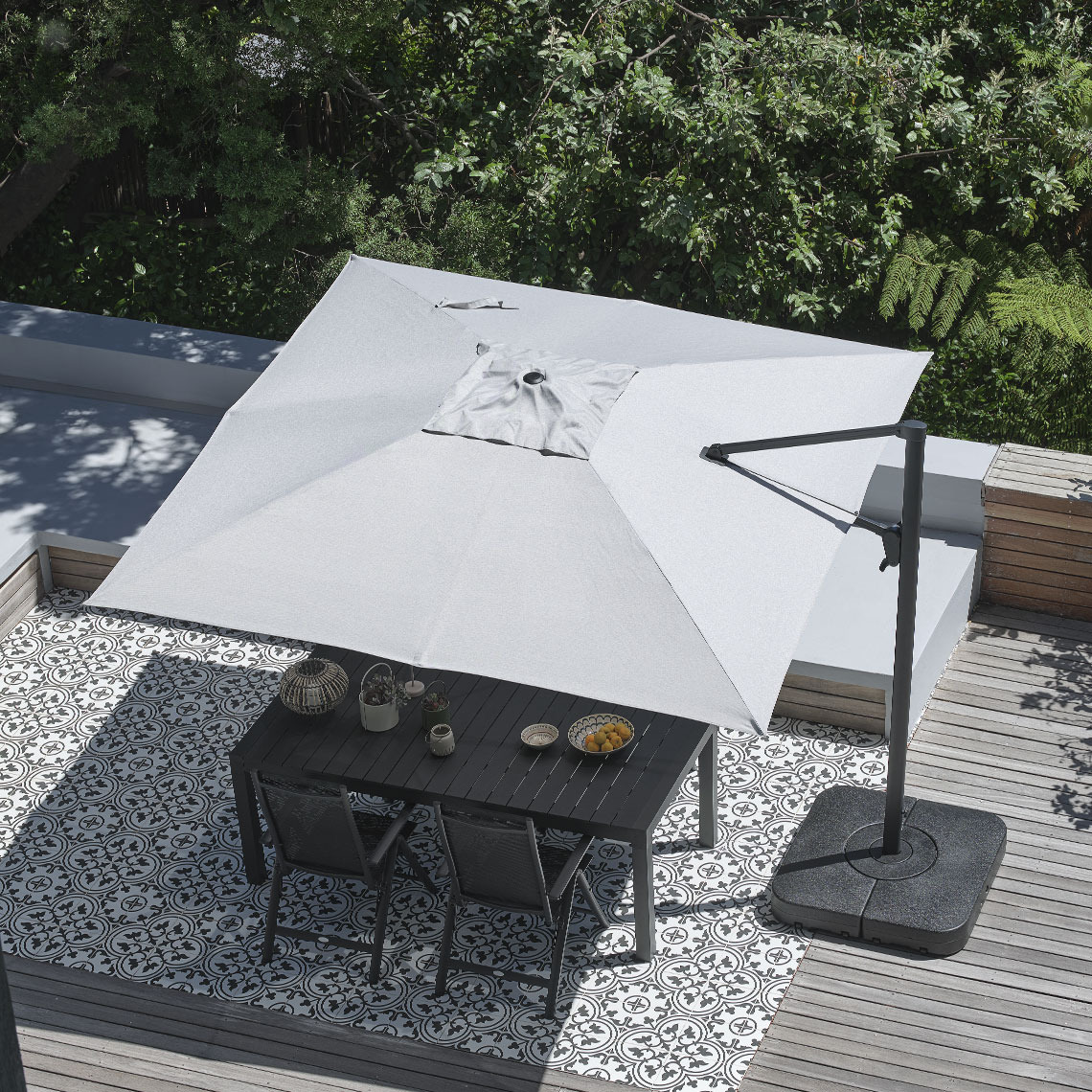 Large, square grey hanging parasol above outdoor dining table with garden chairs