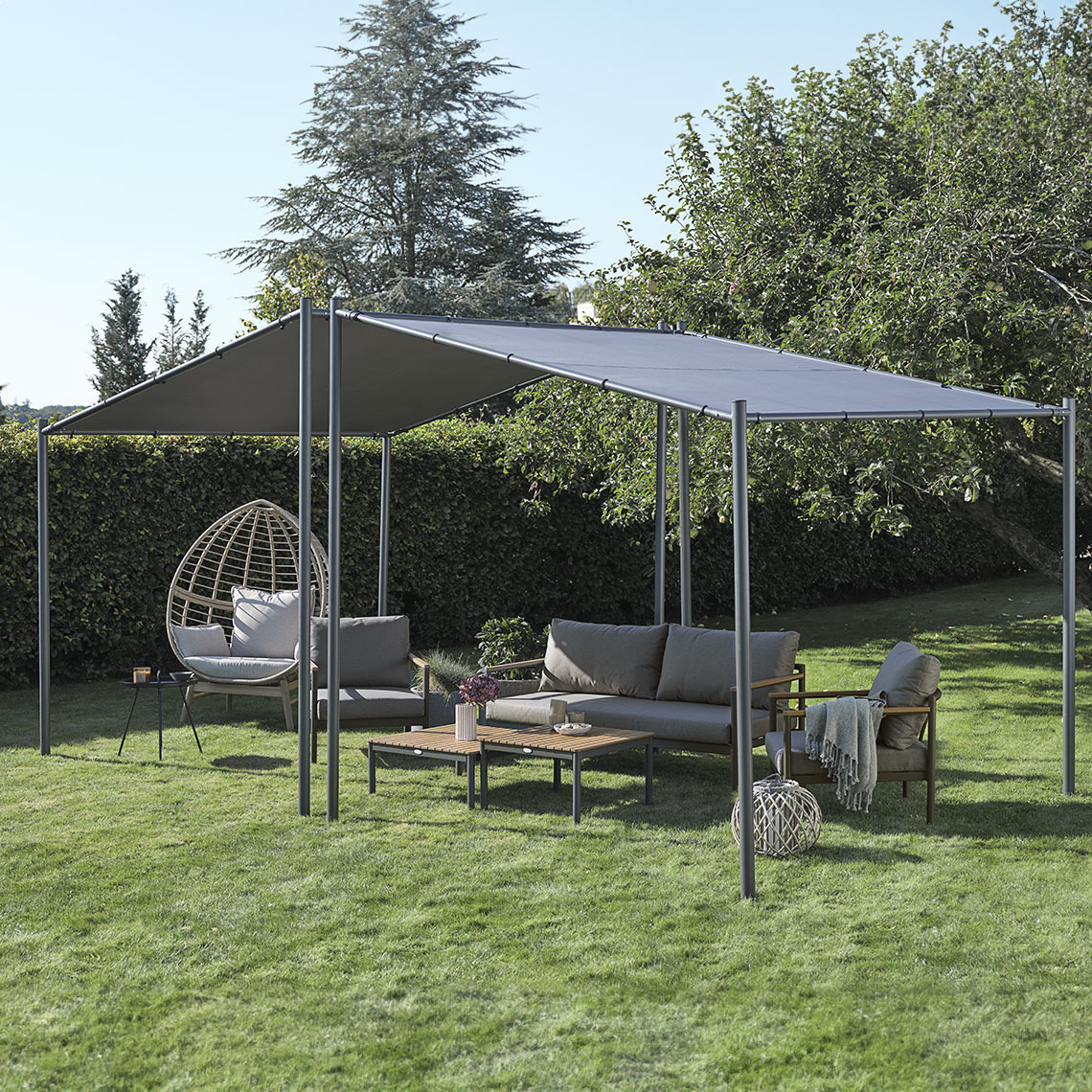 Large grey gazebo in a garden with lounge furniture