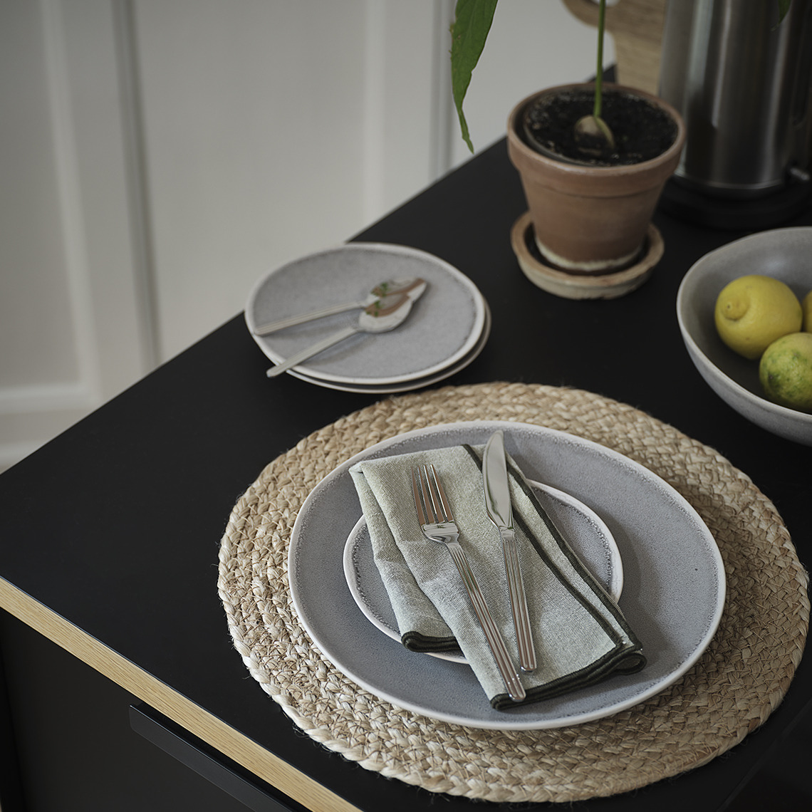 Table set with place mats, stoneware plates, drinking glasses and cutlery