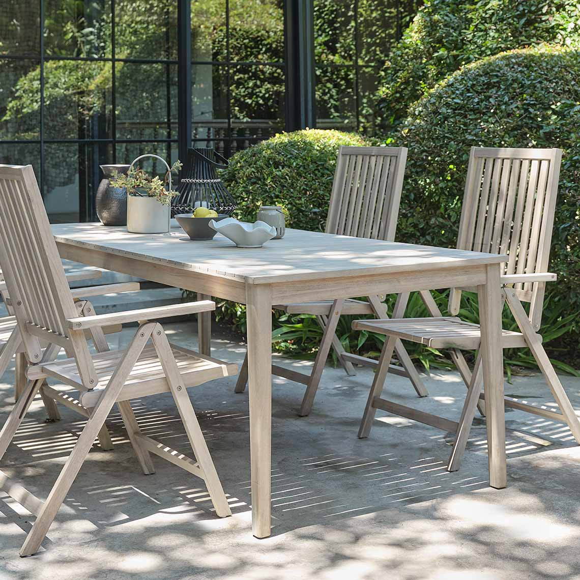 White-oiled hardwood garden table and garden chairs on patio 