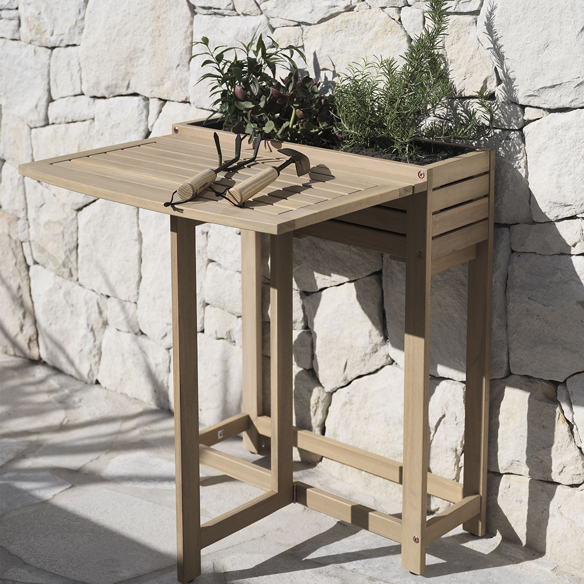 Folding table in hardwood with a built-in planter box standing on a patio