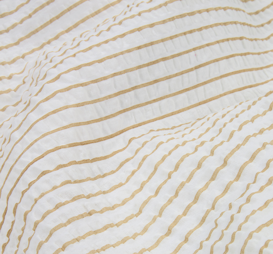 The STINNE duvet cover set is decorated with stripes in latte and white Closeup of striped bed linen