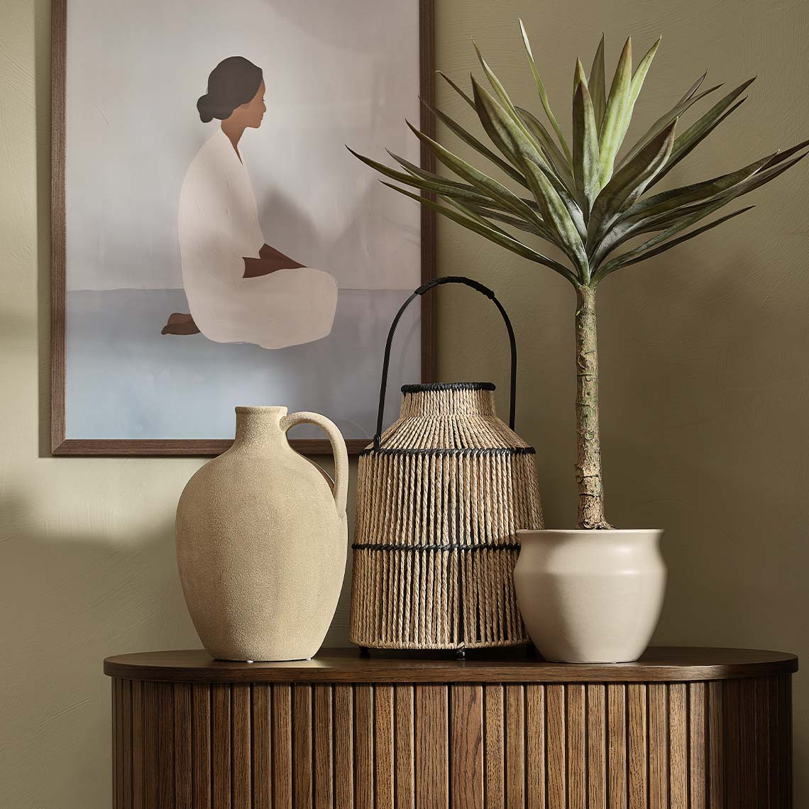 Artificial plant, plant pot, and tall vase on sideboard