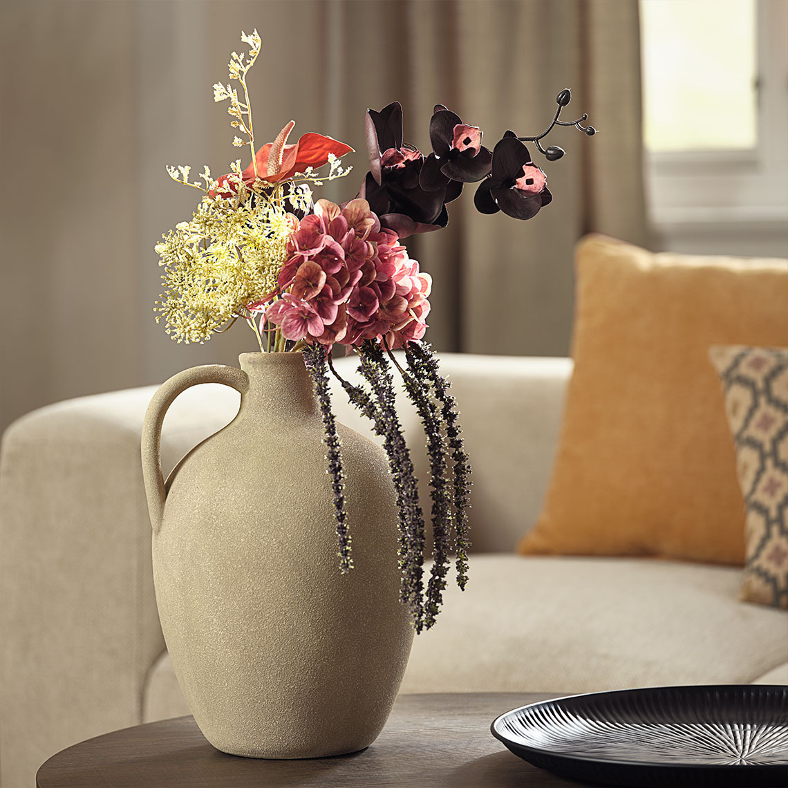 Artificial flower bouquet in vase with handle and rough-sanded, textured surface