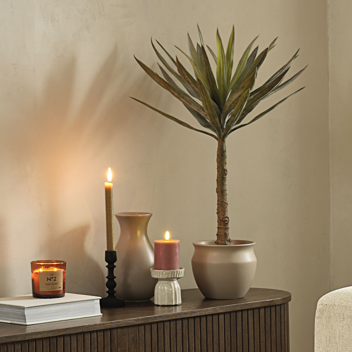 Artificial plant, plant pot, and tall vase on sideboard