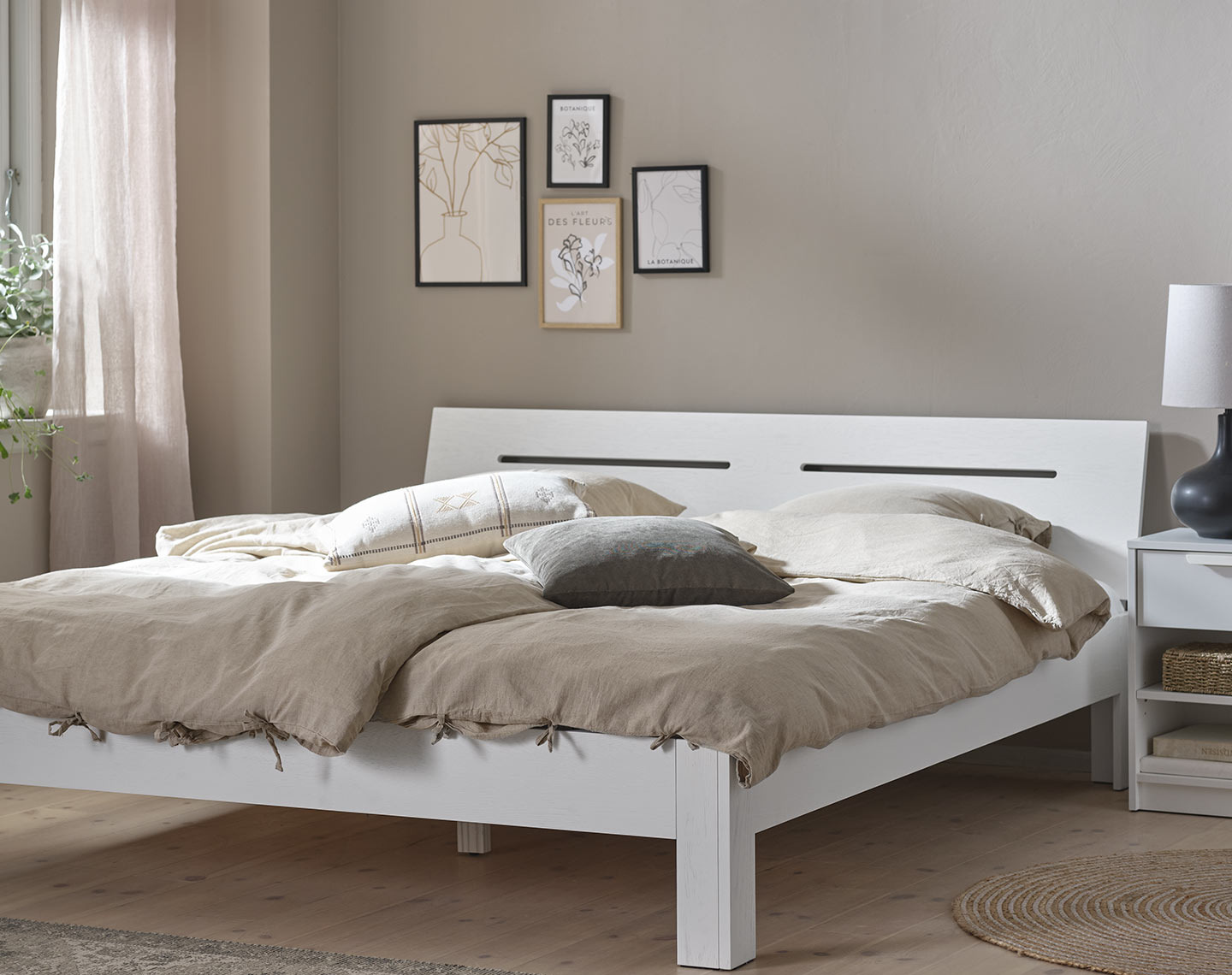 White, wooden bed frame in a bedroom 
