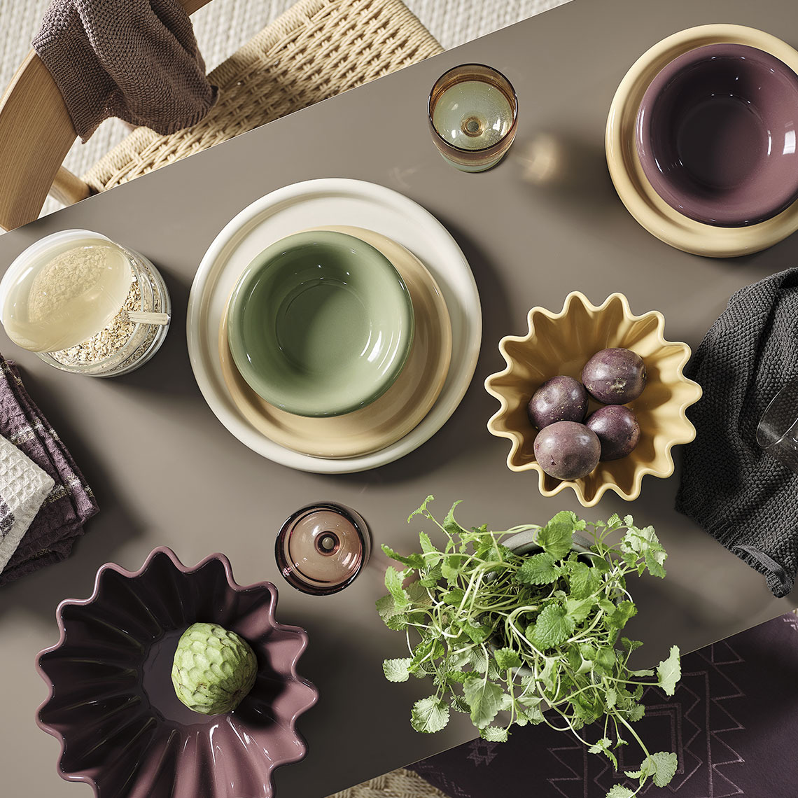 GREGERS cutlery set, MALIK plates and bowls, ISAK drinking glass, TISTEL tea towel, DAHL storage jar, NOR bowls, BARLIND tea towel Colourful bowls and plates on a dining table