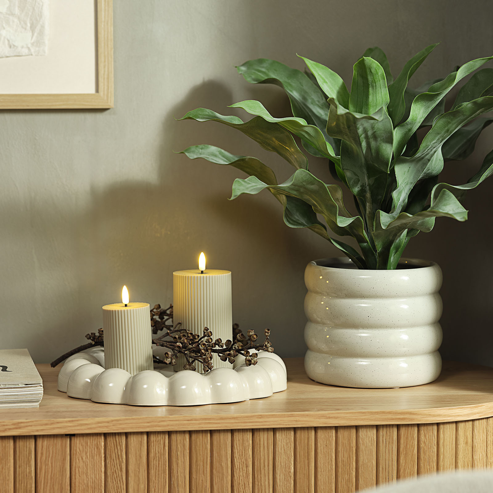 GREGOR decorative tray in warm white Two lit candles in a warm white decorative ceramic tray with bobble edges next to a warm white plant pot