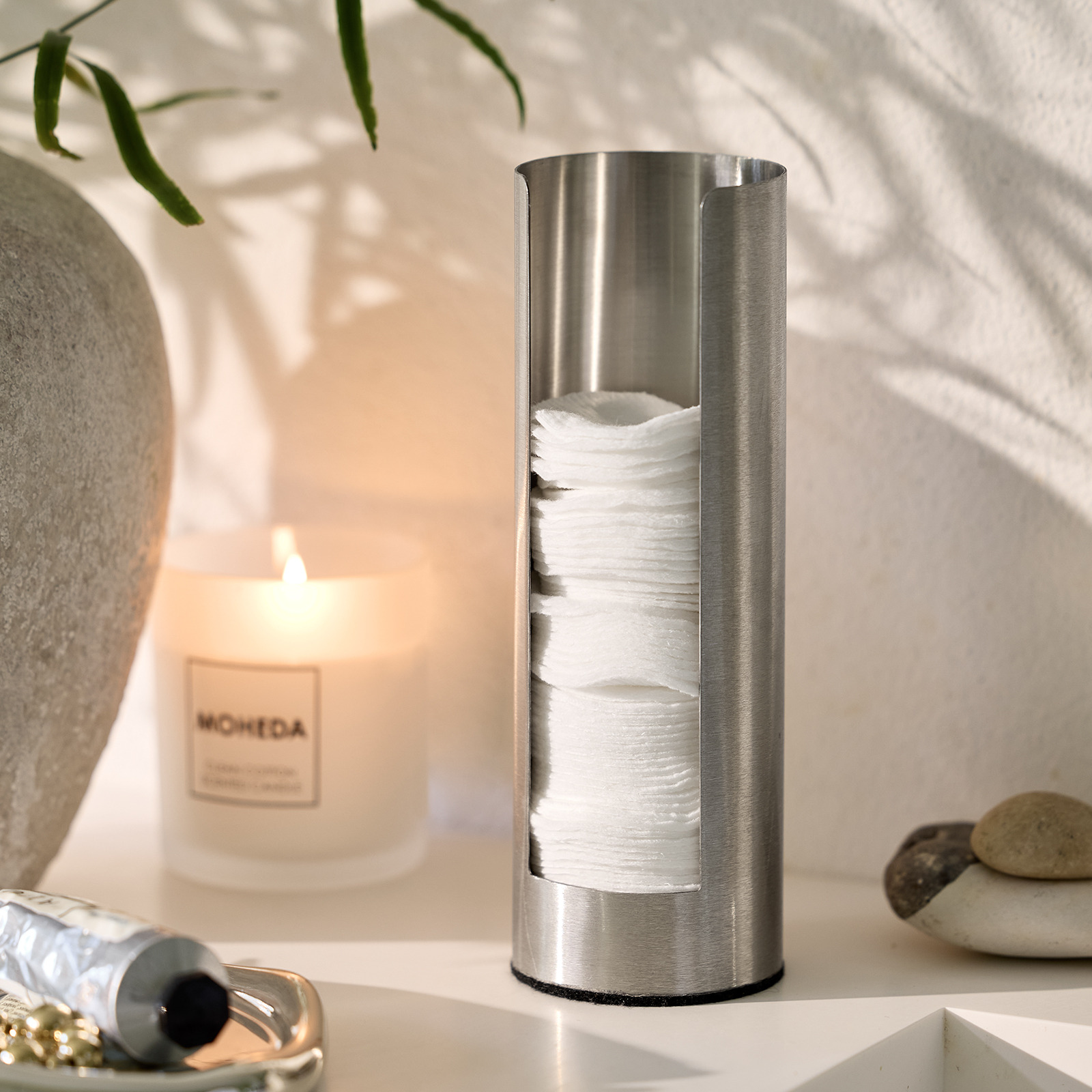 Cotton pad holder and scented candle in a bathroom 