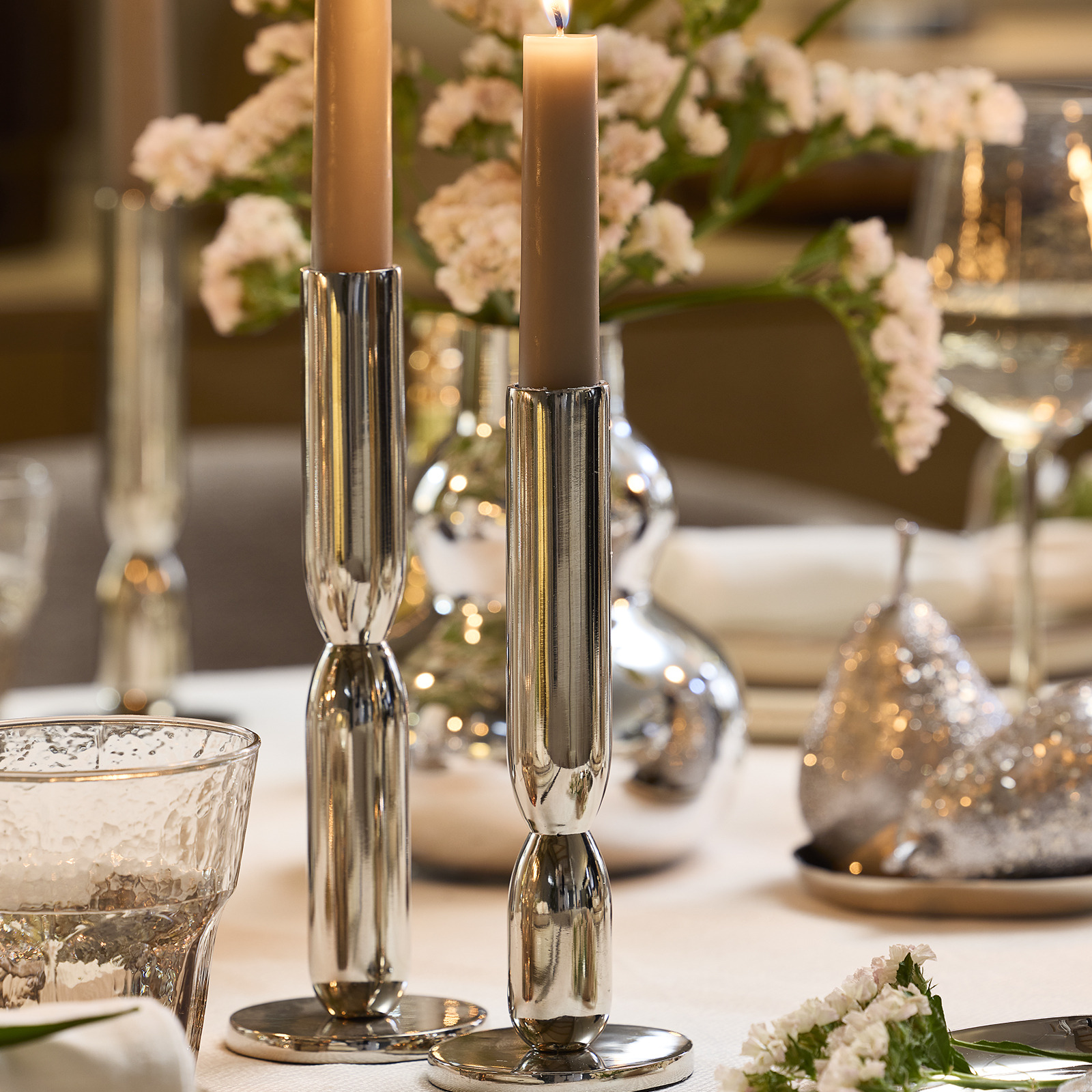 Dinner table with two candlesticks in a silver colour 