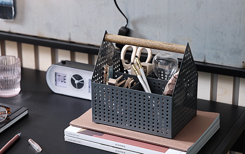 Open storage box with handle, containing scissors, pens, pegs
