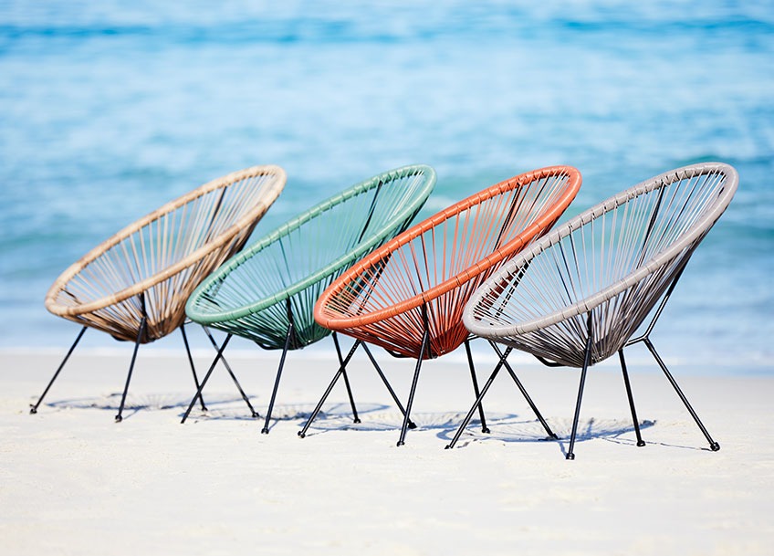 UBBERUP lounge chairs available in green, grey, red and sand Four garden lounge chairs in different colours on a beach
