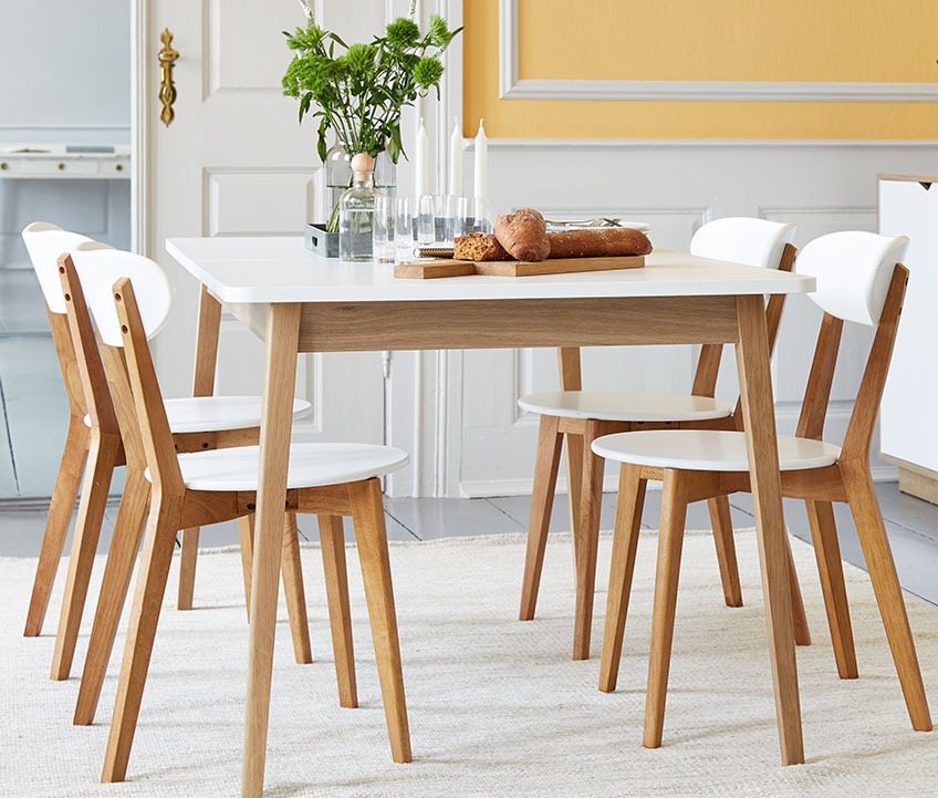 4 dining chairs in wood at a wooden dining table