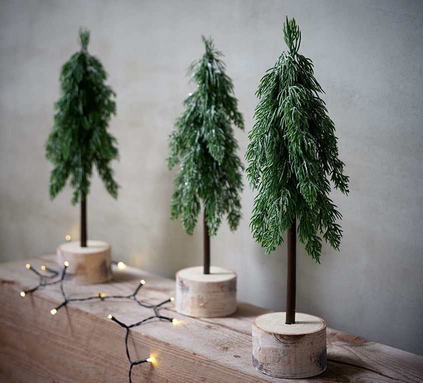 OFIOLIT artificial pine trees Three artificial pine trees on a log represent modern Christmas décor