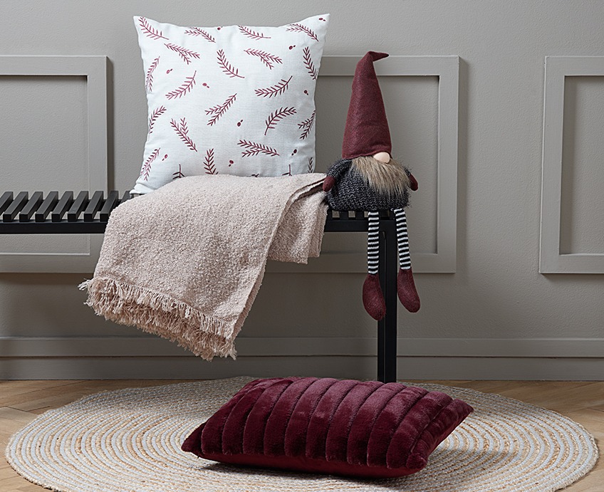 VIRUM bench with KIMBERLIT cushion, NATTLILJA throw and NORNOR elf. On the floor SANDELTRE rug and KORNSTEN cushion. Bench with a cushion, a throw and an elf. On the floor in front of the bench, a red cushion on a round rug.