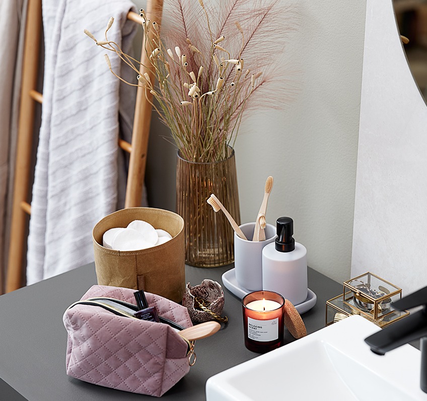 Scented candle, bathroom set and toiletry bag as bathroom décor 